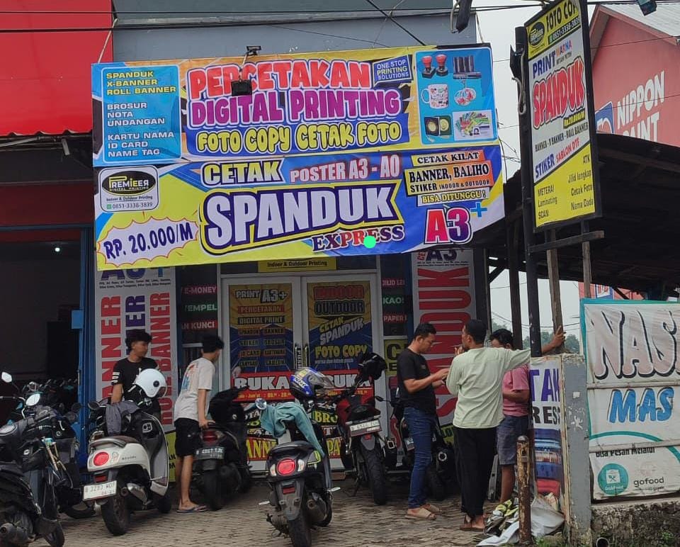 Tampak depan toko PREMIEER Digital Printing di Jl. Raya Muchtar No.65 Sawangan, Depok — spanduk layanan cetak dan pelanggan yang sedang dilayani